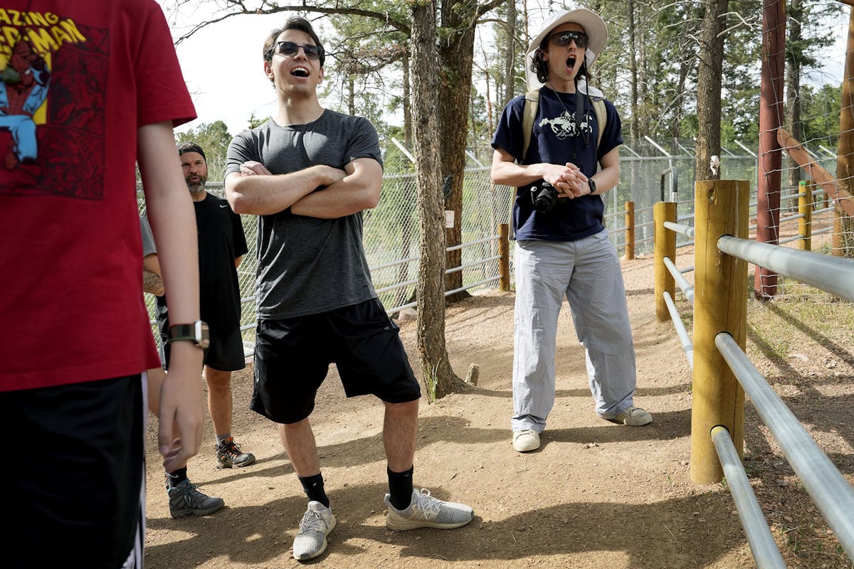 Clay Arnold '24, left to right, and Owen Cox '24 join in the group howl, where all participants are urged to howl and in response, the wolves throughout the Colorado Wolf and Wildlife Center howl back. Photo by Jamie Cotten / Colorado College